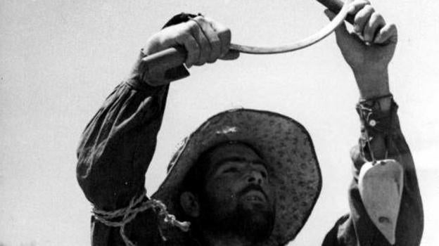 Un campesino en 1936 avanza hacia Zaragoza para combatir haciendo el símbolo comunista.