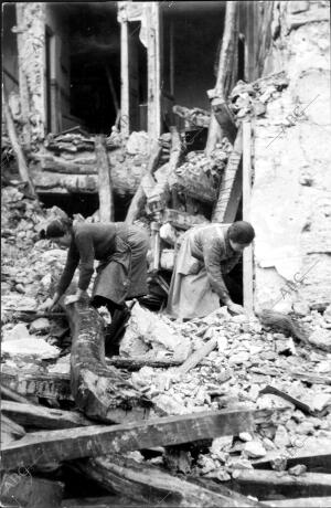 Mujeres Buscando en los Escombros de unos Edificios Destruidos por un Bombardeo,...