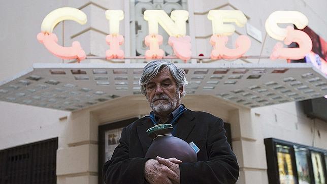 El actor Antonio Mayans sostiene la urna con las cenizas del cineasta madrileño Jesús Franco, que fue despedido en el cine Albéniz