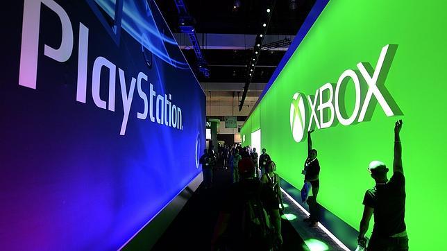 Un grupo de hombres cAmina entre anuncios de XBox y Playstation durante la Feria E3