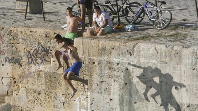 Dos jóvenes se tiran al río desde un puente