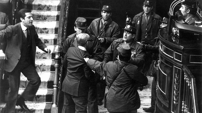 Adolfo Suárez, presidente del Gobierno de UCD, sale de su escaño en el momento en que los golpistas entran en el hemiciclo