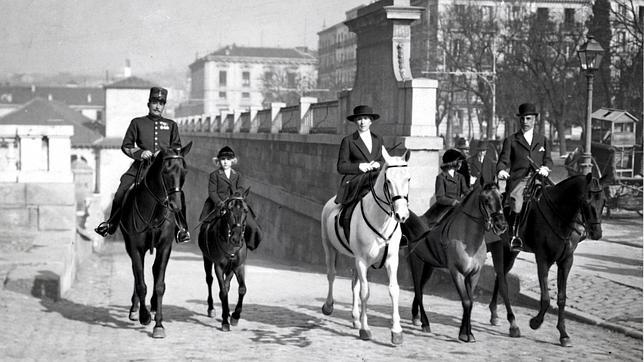 S.M. la Reina Doña Victoria, con las infantitas Doña Beatriz y Doña Cristina, al regresar a las caballerizas reales tras un paseo a caballo por la Casa de Campo