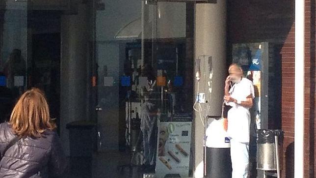 Un paciente con sonda y fumando en la puerta de un hospital