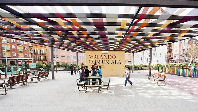 Un toldo hecho de telas de varios colores da sombra y vida a la plaza del Poeta Leopoldo de Luis