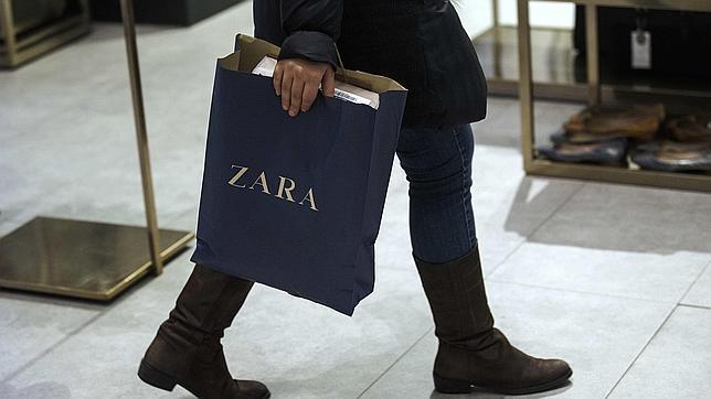 Una mujer lleva una bolsa de Zara en una de las tiendas de la marca perteneciente al Grupo Inditex