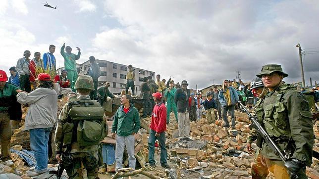 Soldados y equipos de rescate trabajan entre los escombros en Bogotá tras la explosión de una bomba mientras juraba Álvaro Uribe como presidente de Colombia