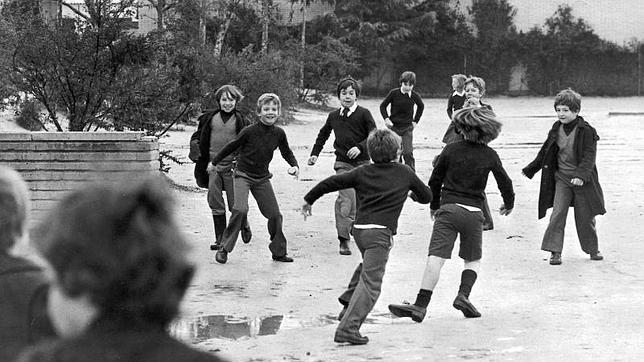 Don Felipe juega con sus compañeros de colegio en el patio en 1977