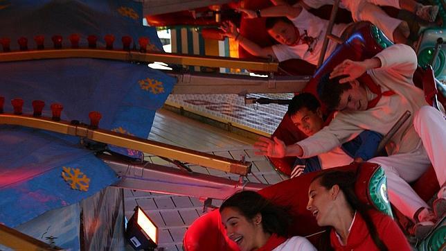 Jóvenes en una de las atracciones de las barracas