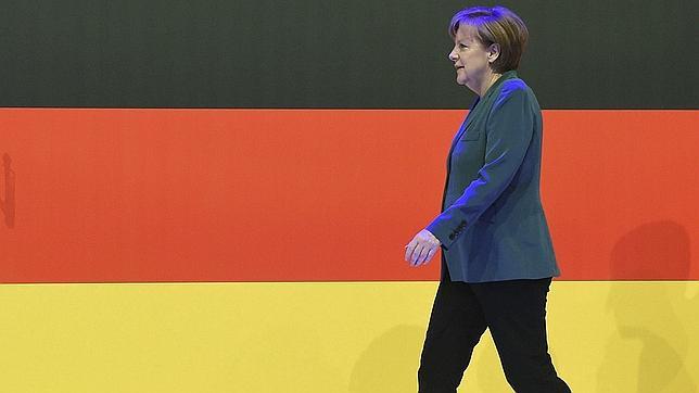 La canciller alemana, Angela Merkel, camina por delante de una bandera germana, en Hannover