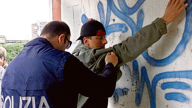 Un policía registra a un hombre sospechoso de pertenecer a la camorra