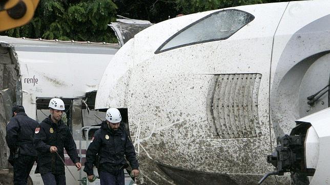 Agentes de la Policía rastrean los restos del tren, depositados en la nave de A Escravitude