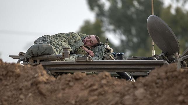 Un soldado israelí descansa sobre un vehículo en la Franja de Gaza