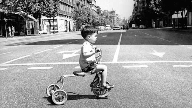 Un niño cruza la calle Serrano esquina con la de Alcalá montado en su triciclo