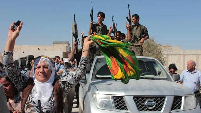 Guerrilleros y civiles kurdos, en la asediada Kobane (Siria)