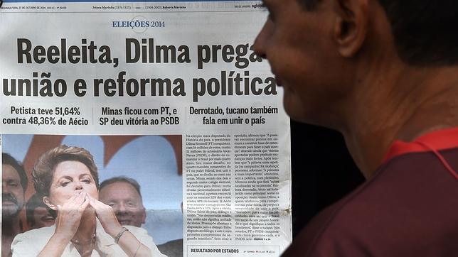 Un hombre se detiene y mira la portada con la victoria de la presidenta Rousseff