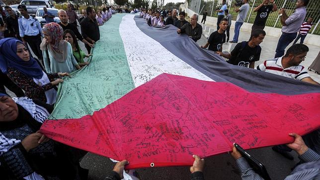 Palestinos sostienen una bandera en el décimo aniversario de Arafat