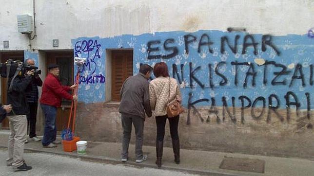 La familia Ulayar, limpiando las pintadas proetarras de la fachada de su casa en septiembre de 2013