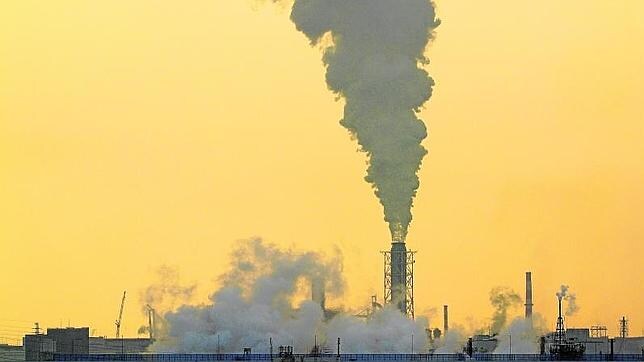 Una columna de humo que emana la chimenea de una fábrica en la bahía de Tokio (Japón)