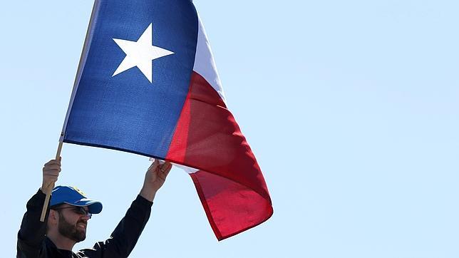Un hombre sujeta la bandera de Texas durante el circuito de Austin