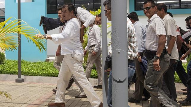 Rafael Correa carga con un niño mientras recorre un centro educativo en Nuevo Rocafuerte (Ecuador)