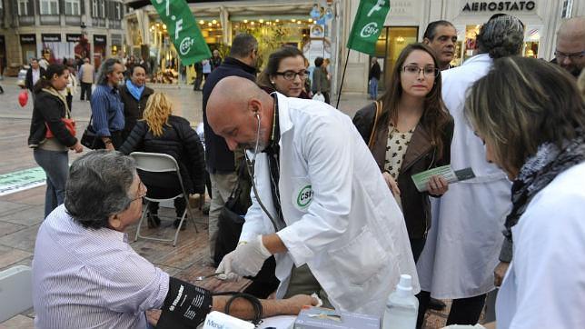 Dos médicos que participaban en una protesta contra los recortes auxilian a un hombre que sufría un infarto