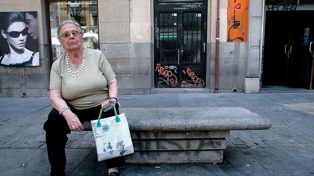 Una madrileña descansa en un banco en el barrio de Chueca