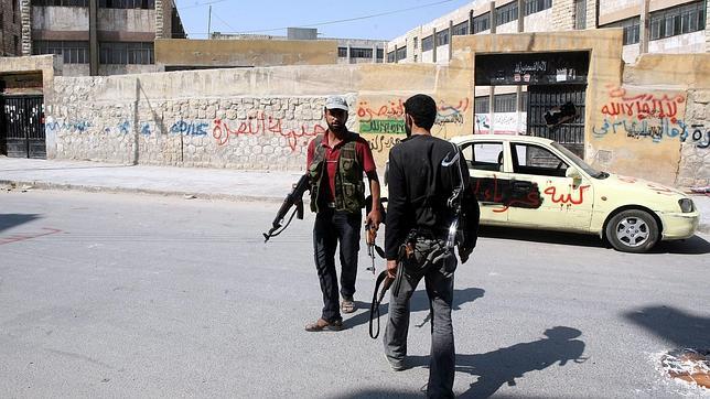 Rebeldes sirios patrullan por las calles de Alepo en agosto de 2012
