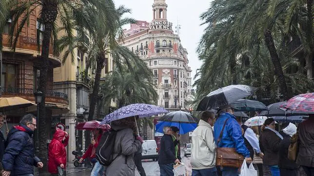 Un grupo de personas se protege de la lluvia en Valencia en una imagen de archivo