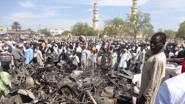 Residentes observan las motocicletas quemadas en la ciudad nigeriana de Kano donde la mezquita central sufrió el pasado viernes un atentado perpetrado por el grupo islamista Boko Haram