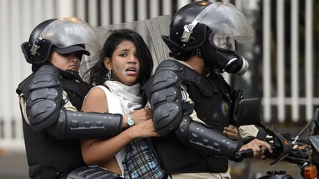 La imagen de la detención de una activista contra Maduro, tomada en marzo, ha sido elegida como «Picture of the year»