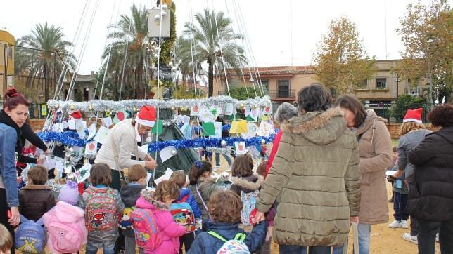 Los niños de Santa Lucía adornan un gran árbol de Navidad