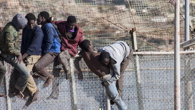 Inmigrantes subidos a la valla. Imagen de archivo