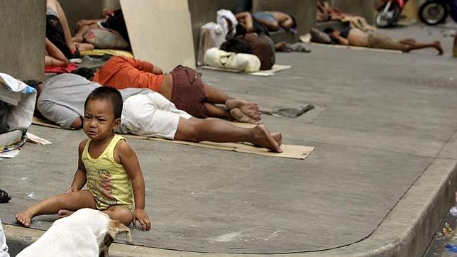 Unos niños vagabundos juegan en una calle de Manila (Filipinas)