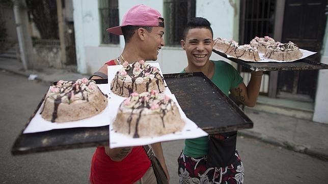 Dos jóvenes llevan tartas caseras para venderlas en el centro de La Habana