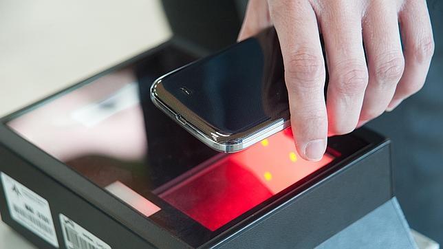 Un pasajero pasa el código de su tarjeta de embarque por el lector electrónico