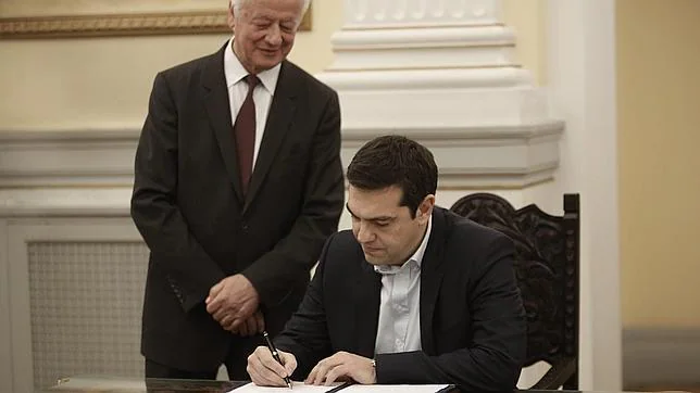 El líder de la izquierdista Syriza, Alexis Tsipras, firma tras jurar como nuevo primer ministro griego