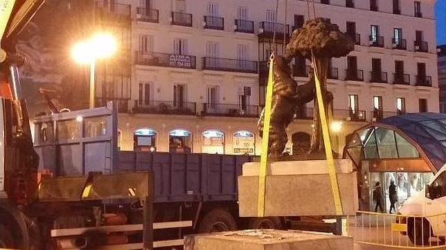 Una grúa vuelve a colocar en su sitio la estatua del Oso y el Madroño de Sol