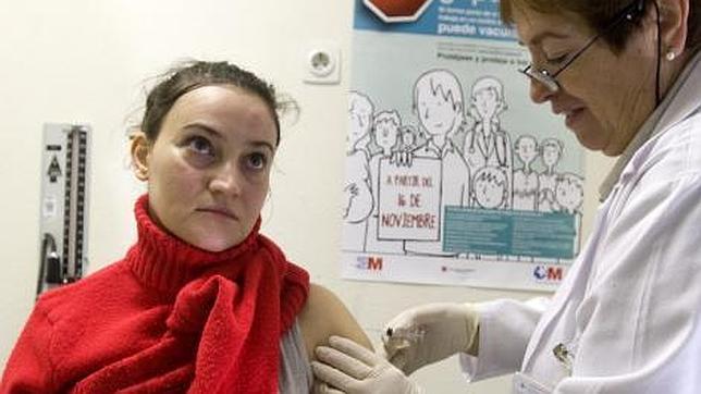Una mujer se vacuna de la gripe en un consultorio de atención primaria de Madrid