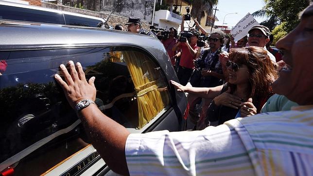 Argentinos tocan el coche fúnebre con los restos del fiscal Alberto Nisman a las puertas del cementerio de La Tablada