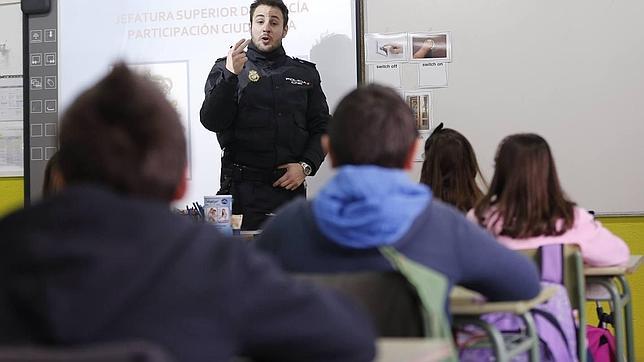Un agente de la Unidad de Participación Ciudadana de la Policía Nacional imparte una charla a escolares de once años en un colegio de Madrid