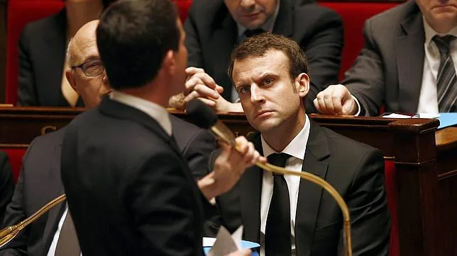 El ministro de Economía, Emmanuel Macron,, escucha el discurso pronunciado por el primer ministro Manuel Valls