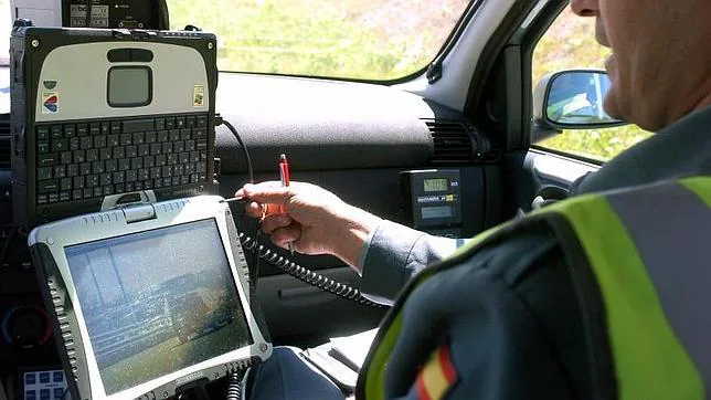 Cámara con pantalla en la que se visualiza la imagen del vehículo que comete la infracción en el interior de un automovil camuflado de la Guardia Civil.