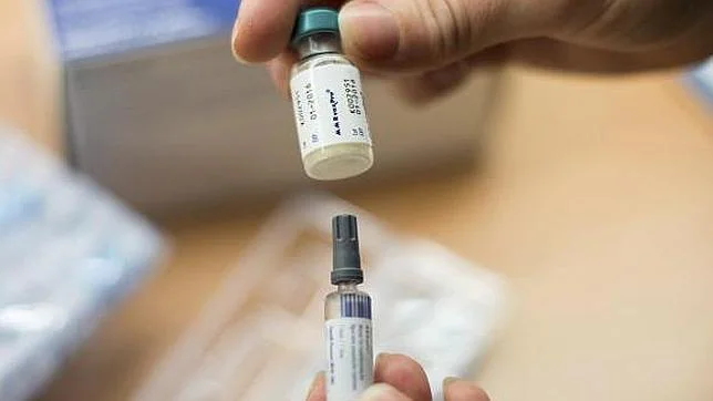 Una mujer prepara una vacuna para el sarampión