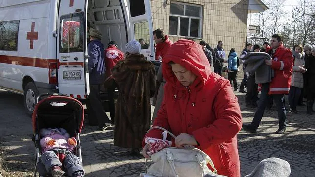Varias personas hacen cola durante el reparto de material por parte de la Cruz Roja