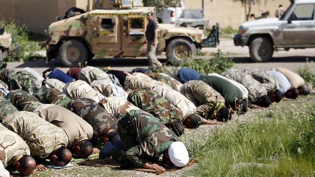 Militares iraquíes y milicianos chiíes rezan el domingo al norte de Bagdad
