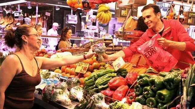 Una mujer adquiere brócoli en la frutería de un mercado