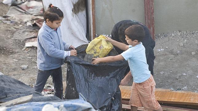Niños jugando con bolsas de basura en el poblado de El Gallinero (Madrid)