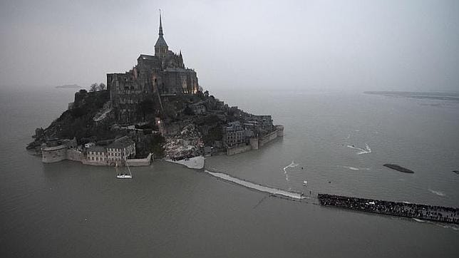 Vista aérea de Mont Saint-Michel, con la marea más alta de los últimos años y miles de turistas contemplando el espectáculo