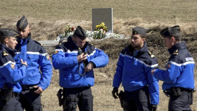 Cinco policías franceses caminan junto al monolito de granito en recuerdo a las víctimas en Seyne les Alpes